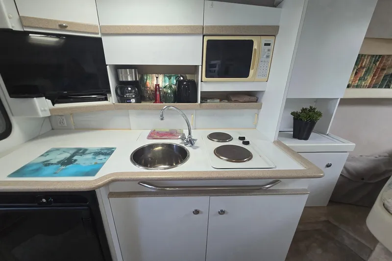 Slide: The Image of Compact kitchen in a 1997 Formula 34 Performance Cruiser with stove, sink, and microwave. - 28