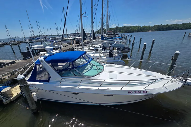 Slide: The Image of 1997 Formula 34 Performance Cruiser docked at a marina under a clear blue sky. - 3