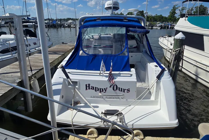Slide: The Image of 1997 Formula 34 Performance Cruiser docked at marina, featuring blue canopy and American flag. - 5