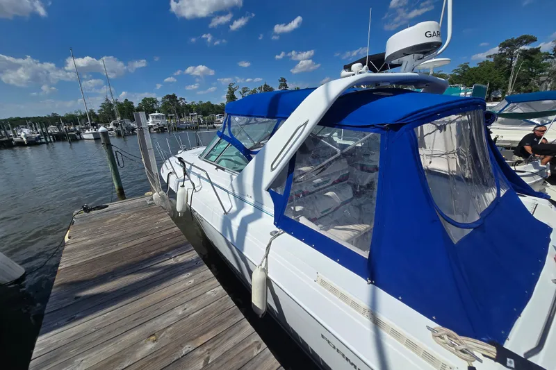Slide: The Image of 1997 Formula 34 Performance Cruiser docked, featuring blue canopy and clear windows under a sunny sky. - 7