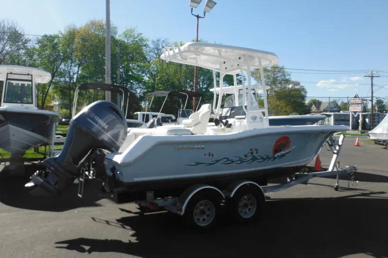 Slide: The Image of 2024 Tidewater 210 LXF boat with Yamaha engine on trailer, displayed outdoors. - 2