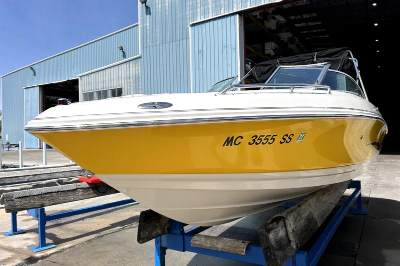 Slide: The Image of 2003 Monterey 218LS Montura Bowrider with yellow hull on display at a marina. - 1