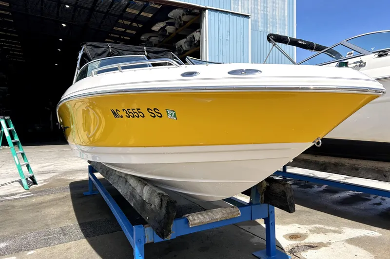 Slide: The Image of 2003 Monterey 218LS Montura Bowrider with yellow hull on a boat stand. - 2