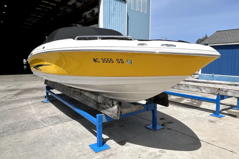 Slide: The Image of 2003 Monterey 218LS Montura Bowrider in yellow, displayed on a blue boat stand. - 27