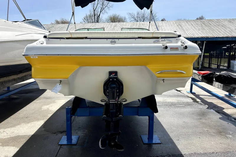 Slide: The Image of 2003 Monterey 218LS Montura Bowrider with yellow and white hull on a boat lift. - 3