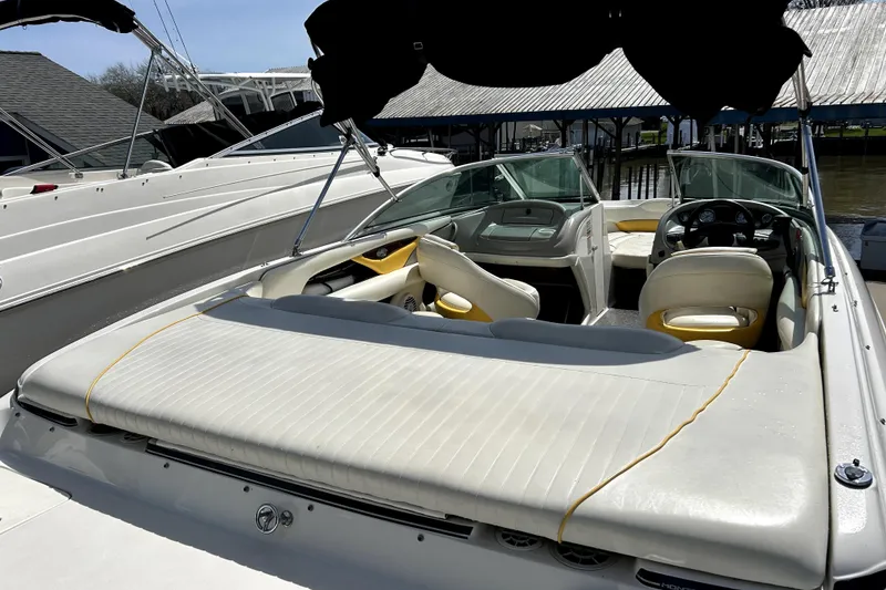 Slide: The Image of 2003 Monterey 218LS Montura Bowrider with white seating and black canopy at dock. - 7
