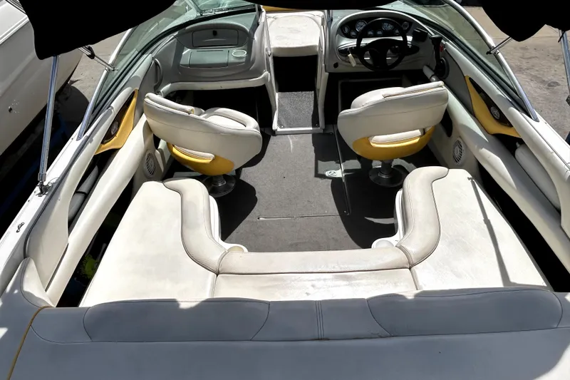 Slide: The Image of Interior of a 2003 Monterey 218LS Montura Bowrider, featuring white and yellow seating. - 9