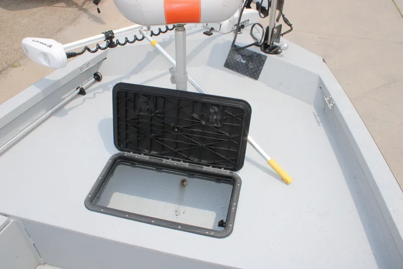 Slide: The Image of 2018 G3 Bay 18 DLX boat deck with open storage compartment and trolling motor. - 18