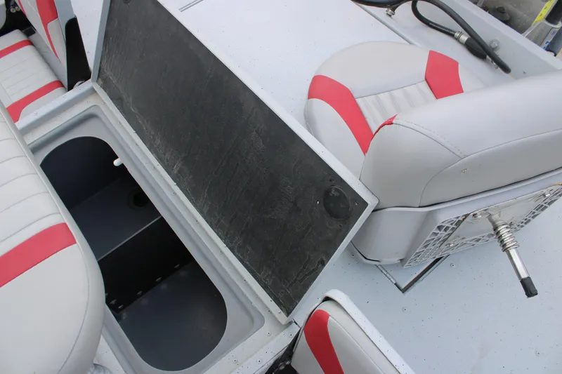 Slide: The Image of 2018 G3 Bay 18 DLX boat interior with open storage compartment and red-accented seating. - 8