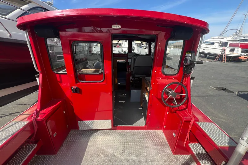 Slide: The Image of Red 2018 Hewescraft 240 Pacific Cruiser Hardtop boat interior with steering wheel and seating. - 3