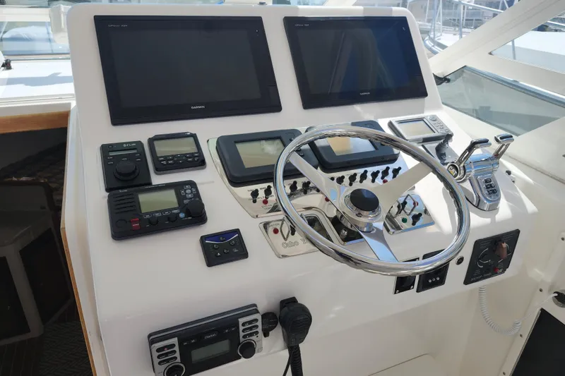 Slide: The Image of Control panel of a 2009 Cabo 36 Express boat with steering wheel and navigation equipment. - 12
