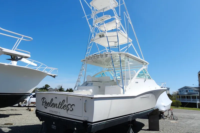 Slide: The Image of 2009 Cabo 36 Express boat on land, featuring a tall tower and sleek design. - 3