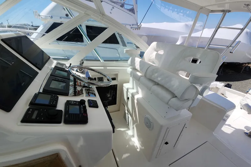Slide: The Image of Helm of 2009 Cabo 36 Express yacht with modern navigation equipment and white seating. - 9