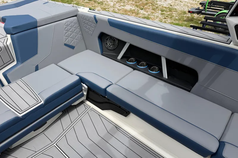 Slide: The Image of 2026 Nautique Super Air Nautique GS24 interior with blue and gray seating and cup holders. - 12