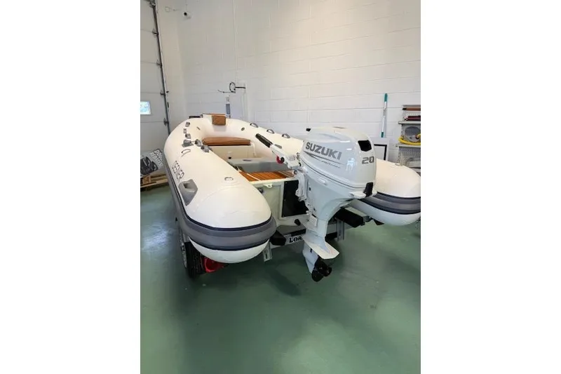 The Image of Inflatable boat Desner Classic CL 340 (2026) with Suzuki 20 HP outboard motor in garage. - 1
