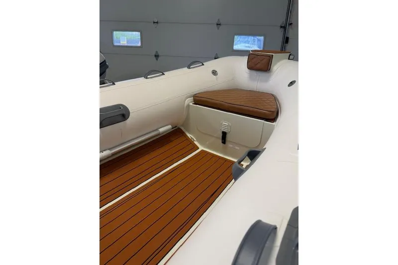 Slide: The Image of Interior of 2026 Desner Classic CL 340 boat with cushioned seating and wood-style flooring. - 3