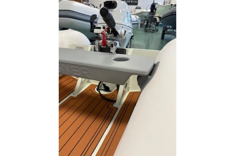 Slide: The Image of Desner Classic CL 340 boat interior with motor, 2026 model, featuring wood-patterned flooring. - 7