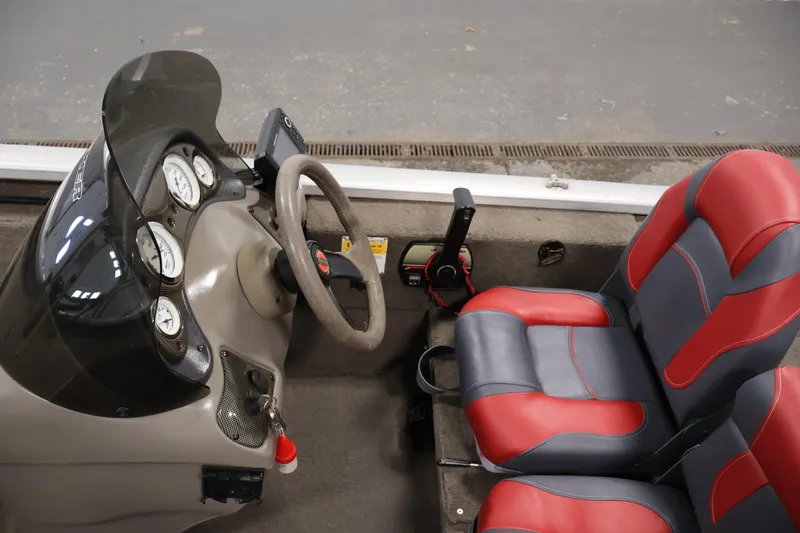 Slide: The Image of 2003 Tracker Pro Team 175 boat interior with steering wheel and red-gray seats. - 21