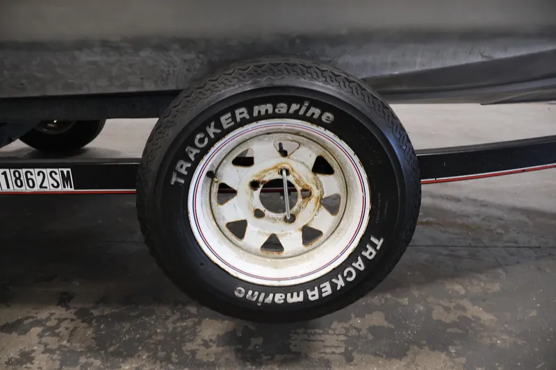 Slide: The Image of 2003 Tracker Pro Team 175 trailer wheel with Tracker Marine tire in a garage setting. - 45