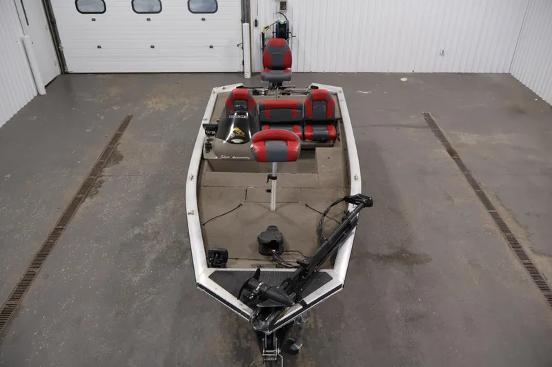 Slide: The Image of 2003 Tracker Pro Team 175 boat with red and gray seating in a garage setting. - 9