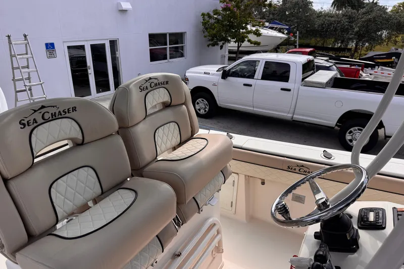 Slide: The Image of 2022 Sea Chaser 27 HFC CC boat interior with plush seating and steering wheel. - 16