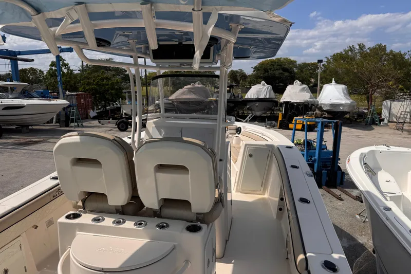 Slide: The Image of 2022 Sea Chaser 27 HFC CC boat in marina, showcasing helm and seating area. - 27
