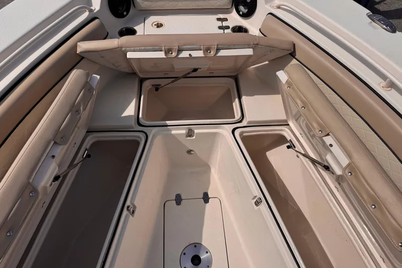 Slide: The Image of 2022 Sea Chaser 27 HFC CC boat interior with open storage compartments and beige seating. - 29