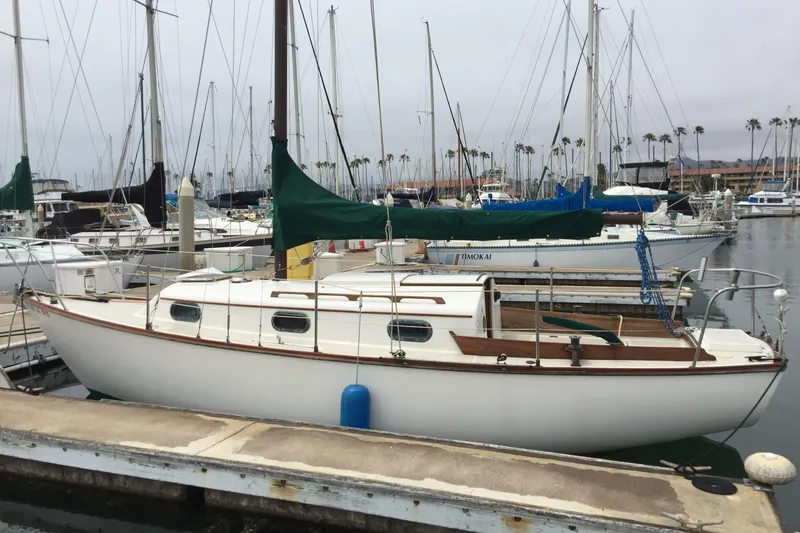 The Image of 1986 Cape Dory 26 sailboat docked in a marina, surrounded by other boats. - 0