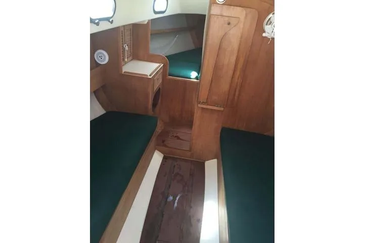 Slide: The Image of Interior of 1986 Cape Dory 26 sailboat with wooden finish and green cushions. - 5