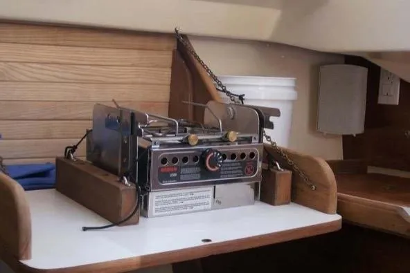 Slide: The Image of 1986 Cape Dory 26 interior with a compact stove on a wooden counter. - 6