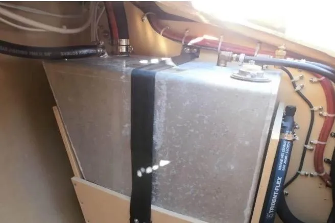 Slide: The Image of Fuel tank inside a 1986 Cape Dory 26 sailboat, secured with straps and connected to hoses. - 16