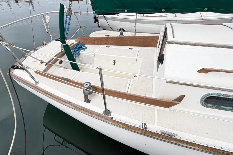 Slide: The Image of 1986 Cape Dory 26 sailboat deck with wooden trim and green sail cover. - 2
