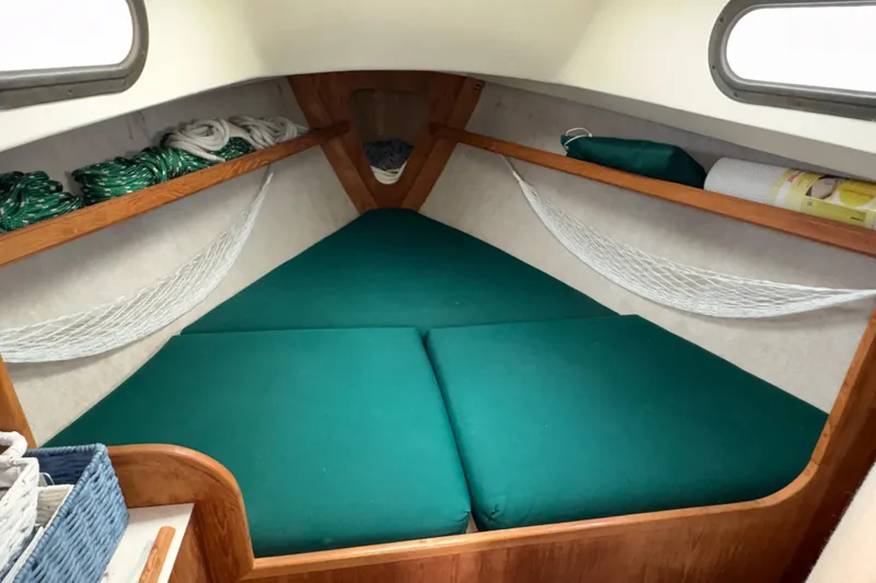 Slide: The Image of Cozy cabin interior of 1986 Cape Dory 26 sailboat with green cushions and storage nets. - 8