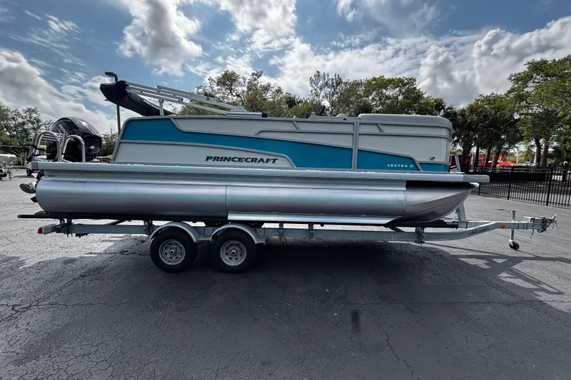 The Image of 2026 Princecraft Vectra 21 RL pontoon boat on trailer, parked outdoors under cloudy sky. - 1