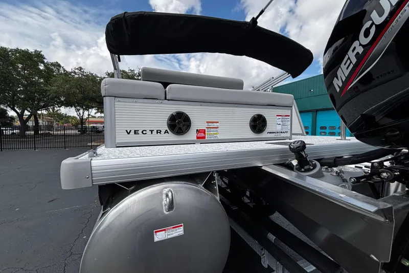 Slide: The Image of 2026 Princecraft Vectra 21 RL pontoon boat with Mercury engine, docked under a cloudy sky. - 6