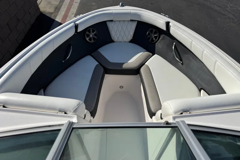 Slide: The Image of 2019 Regal 21 OBX boat interior with cushioned seating and speaker system. - 11