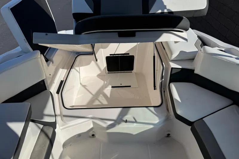 Slide: The Image of 2019 Regal 21 OBX boat interior storage compartment with open hatch and seating area. - 16
