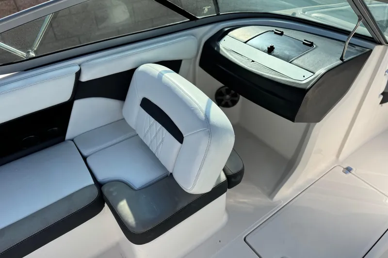 Slide: The Image of 2019 Regal 21 OBX boat interior with white and black seating and dashboard. - 21