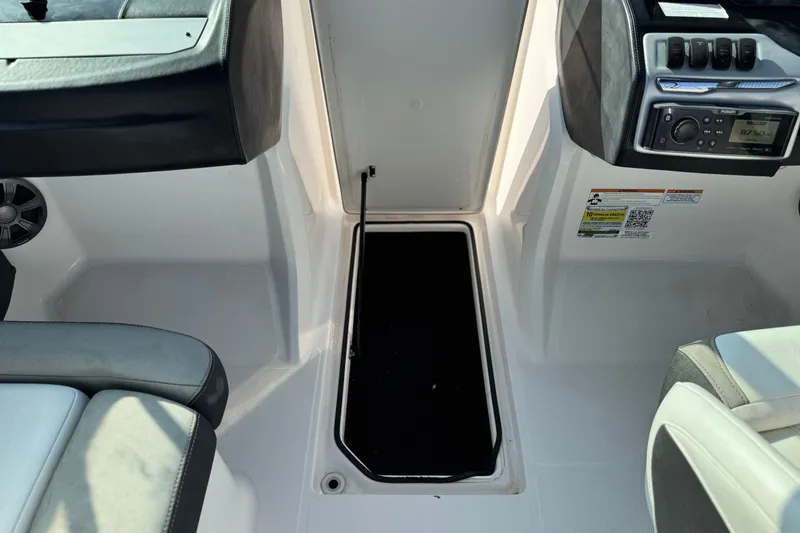 Slide: The Image of 2019 Regal 21 OBX boat interior with storage compartment and control panel. - 22