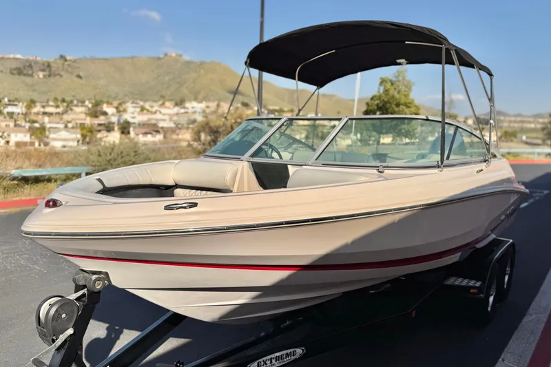 Slide: The Image of 2019 Regal 21 OBX boat with canopy on trailer, parked outdoors. - 3
