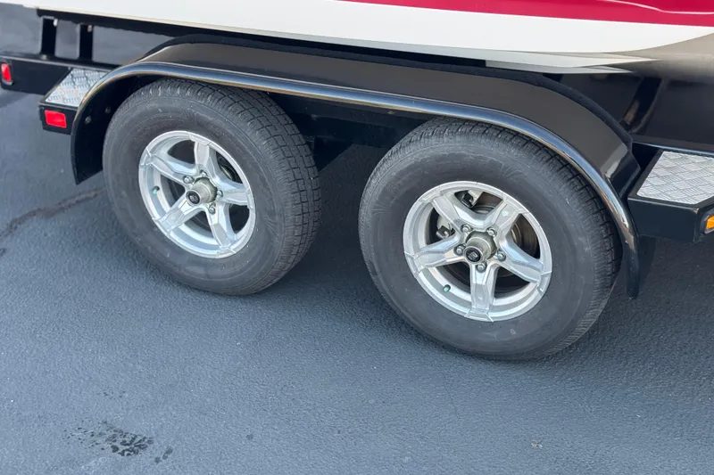Slide: The Image of Trailer wheels of a 2019 Regal 21 OBX boat on a blacktop surface. - 30