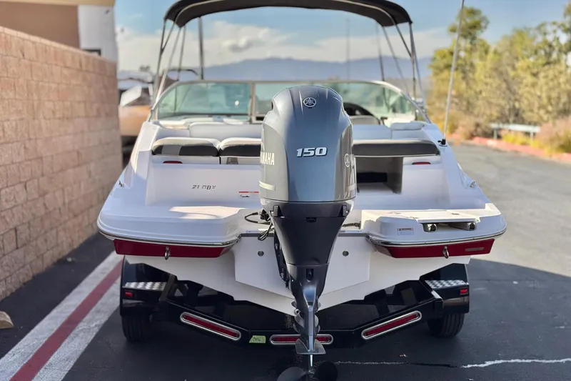 Slide: The Image of 2019 Regal 21 OBX boat with Yamaha 150 outboard motor, parked outdoors. - 4