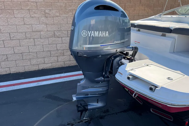 Slide: The Image of 2019 Regal 21 OBX boat with Yamaha outboard motor, parked on pavement. - 6
