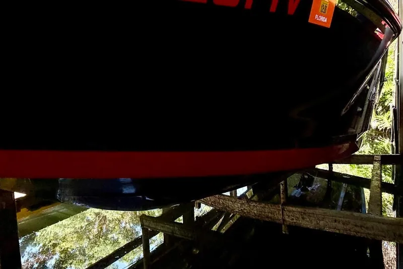 Slide: The Image of 2023 MasterCraft NXT20 boat on a lift, reflecting in calm water. - 11
