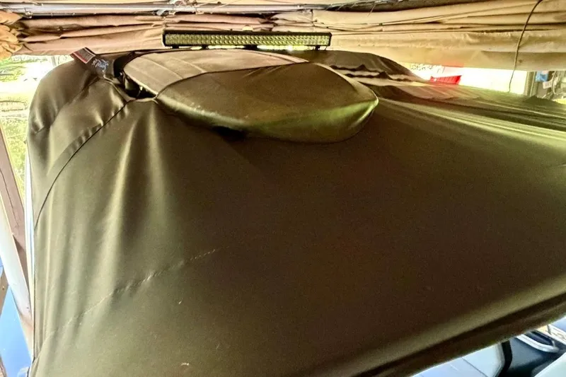 Slide: The Image of 2023 MasterCraft NXT20 boat covered in protective tarp under shelter. - 17