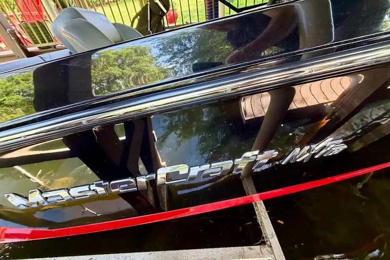 Slide: The Image of 2023 MasterCraft NXT20 boat with sleek black exterior and red accents. - 18