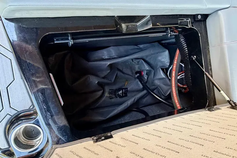Slide: The Image of 2023 MasterCraft NXT20 boat storage compartment with hydraulic lift and wiring. - 22