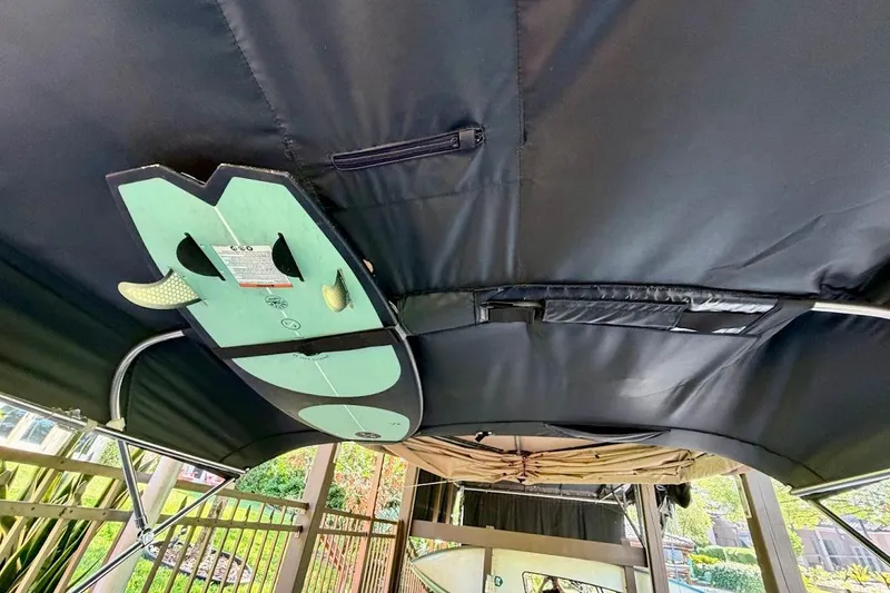 Slide: The Image of 2023 MasterCraft NXT20 boat with surfboard storage under black canopy. - 26