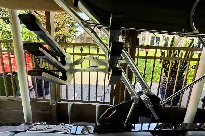 Slide: The Image of 2023 MasterCraft NXT20 boat with a wakeboard rack, docked near a garden. - 27