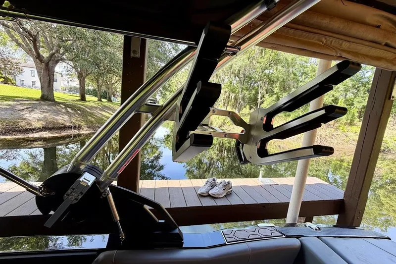 Slide: The Image of 2023 MasterCraft NXT20 boat with wakeboard rack, docked by a serene lake. - 28